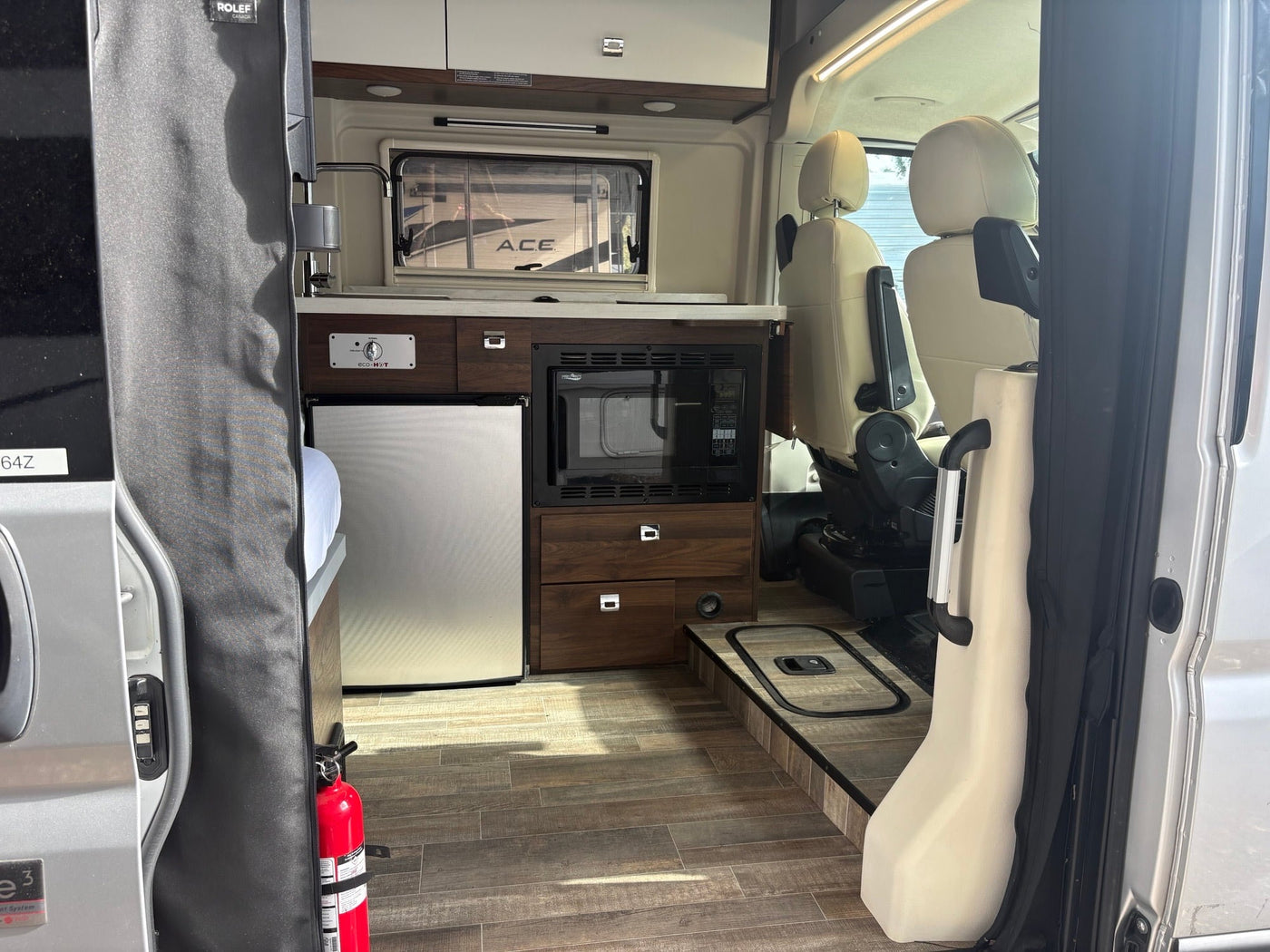  featuring a ladder and bike rack for your next adventure.|Compact rv rental interior shows kitchen with microwave — photo 3