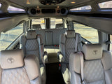 Inside a premium RV rental: light grey quilted leather captain's chairs with unique globe headrests.