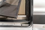 An RV rental's side entrance, featuring a durable black zippered mesh screen opening to the interior.