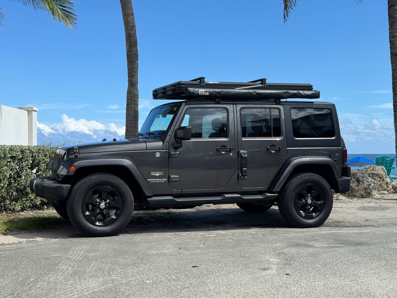 Adventure-ready Jeep Wrangler RV rental with rooftop awning, parked by the beach for outdoor exploration. — photo 6