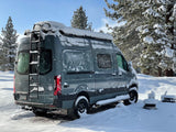 Snow-covered Sprinter camper van for rv rental, ready for winter adventures in the snowy forest.