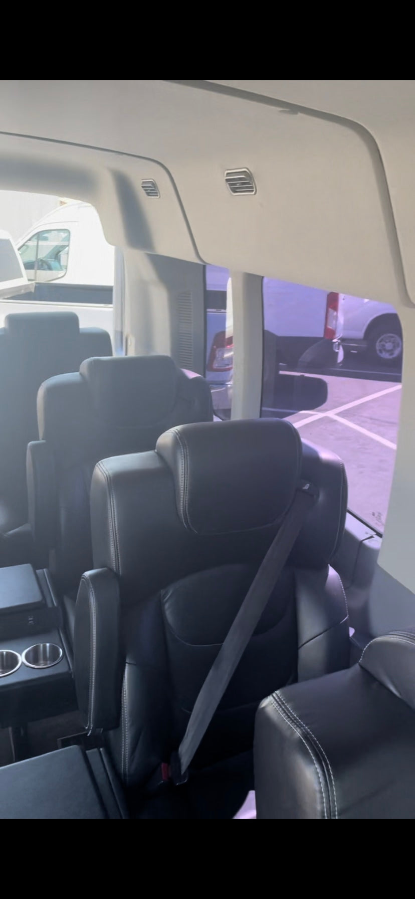 Inside a premium RV rental: comfortable black leather captain's chairs with cup holders, perfect for travel.
