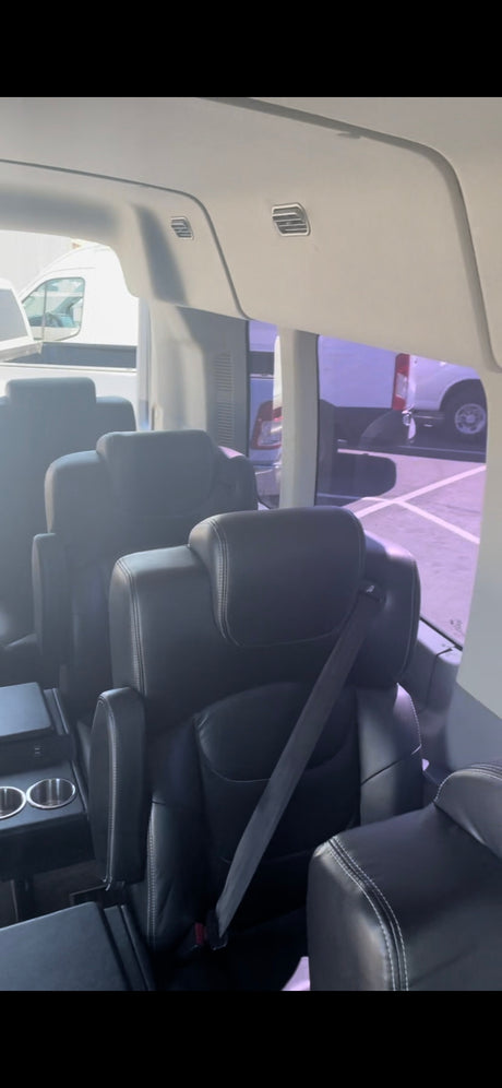 Inside a premium RV rental: comfortable black leather captain's chairs with cup holders, perfect for travel.