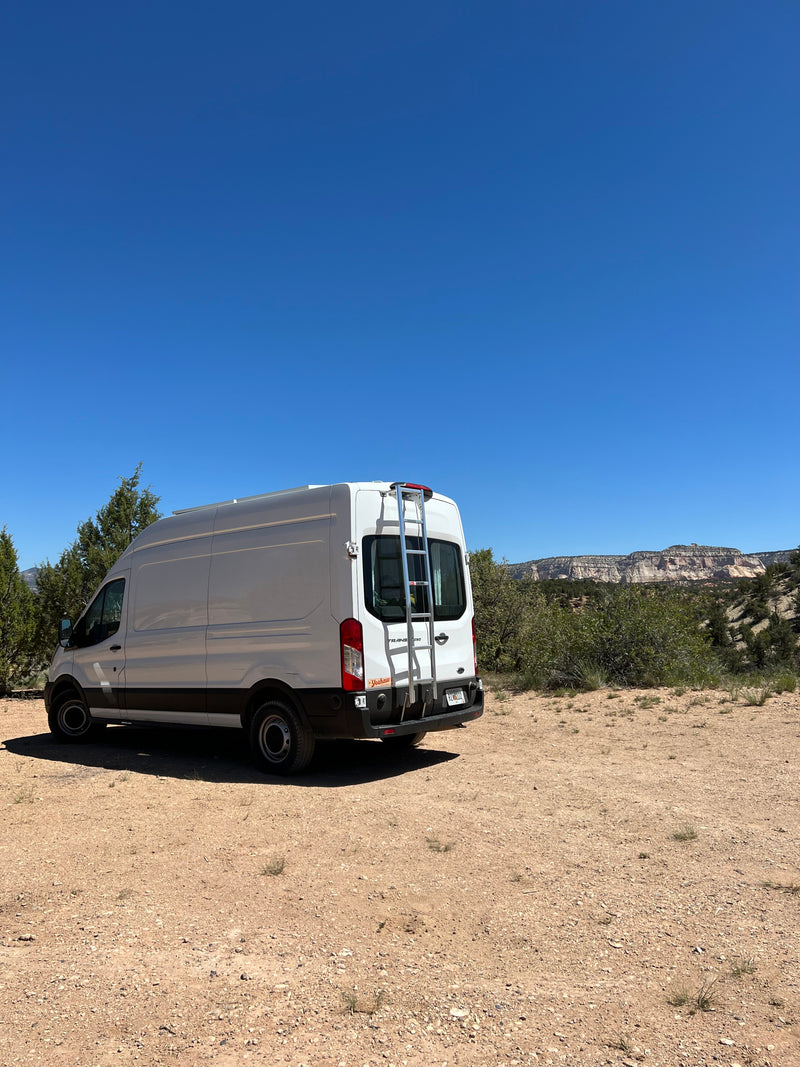 This white Ford Transit **RV rental** is ready for adventure, parked on a dirt road with majestic desert mountains. — photo 6