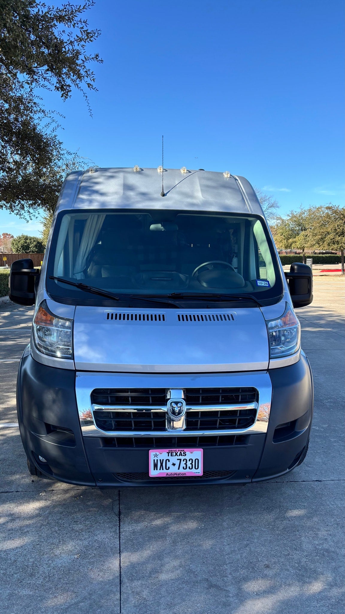 Front view of a silver Ram ProMaster van, ideal for rv rental, parked on concrete under a clear sky. Texas plate WXC-7330 visible. — photo 14