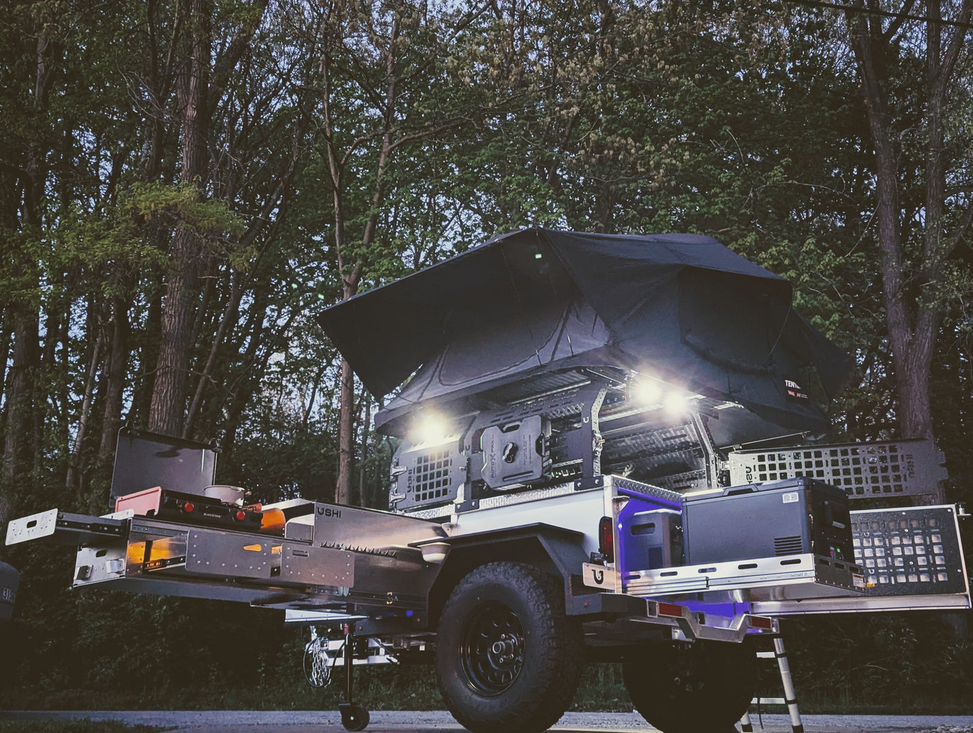 Equipped overland camping trailer: rooftop tent, pull-out kitchen, fridge. Ideal for your next RV rental adventure.
