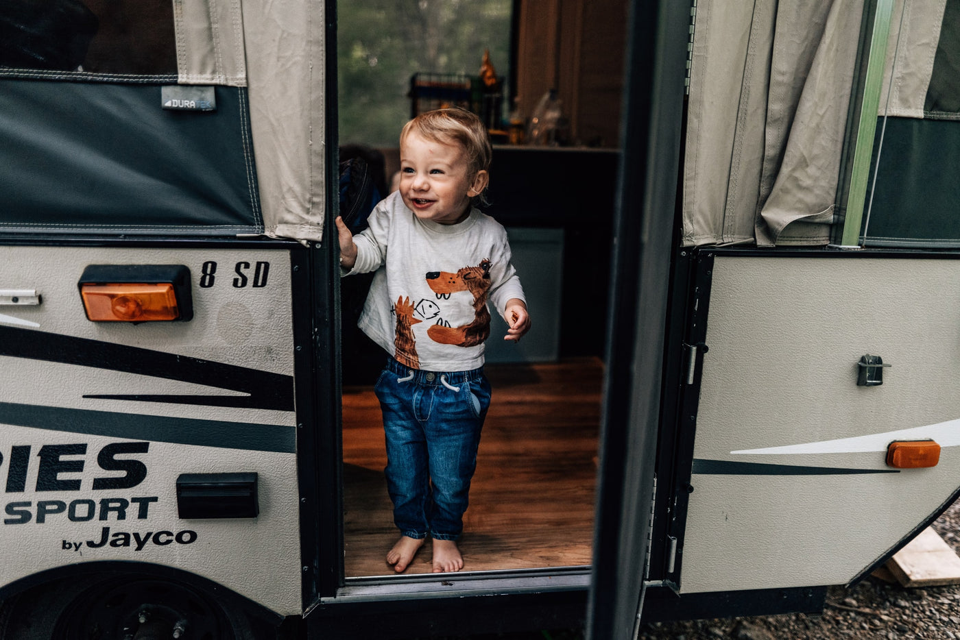 Happy toddler smiles from a Jayco Sport pop-up camper, a perfect rv rental for family adventures. — photo 10