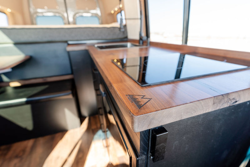  in a snowy field with mountains.|Explore this modern rv rental camper van interior — photo 4