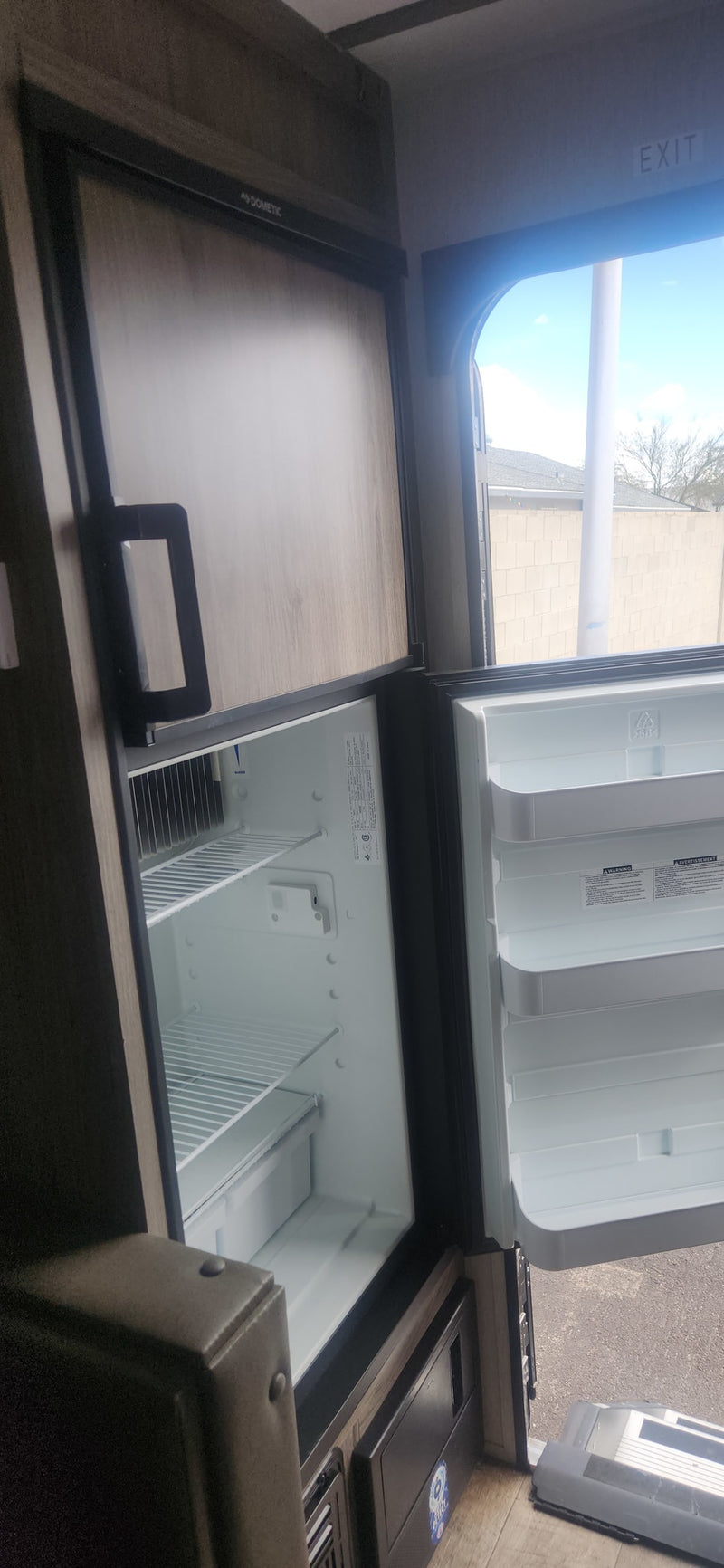  and electric cooktop above stone backsplash & wood cabinets.|RV rental's interior control panel: monitoring battery/tanks — photo 8