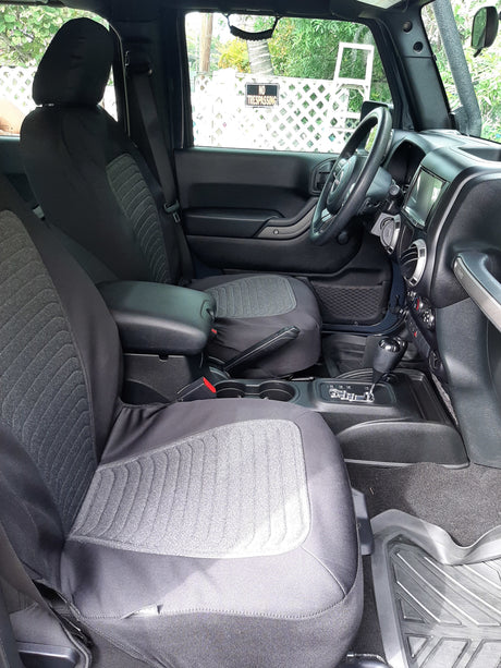 Spacious front vehicle interior, likely a Jeep, with protective seat covers and console controls, ideal for an RV rental adventure.