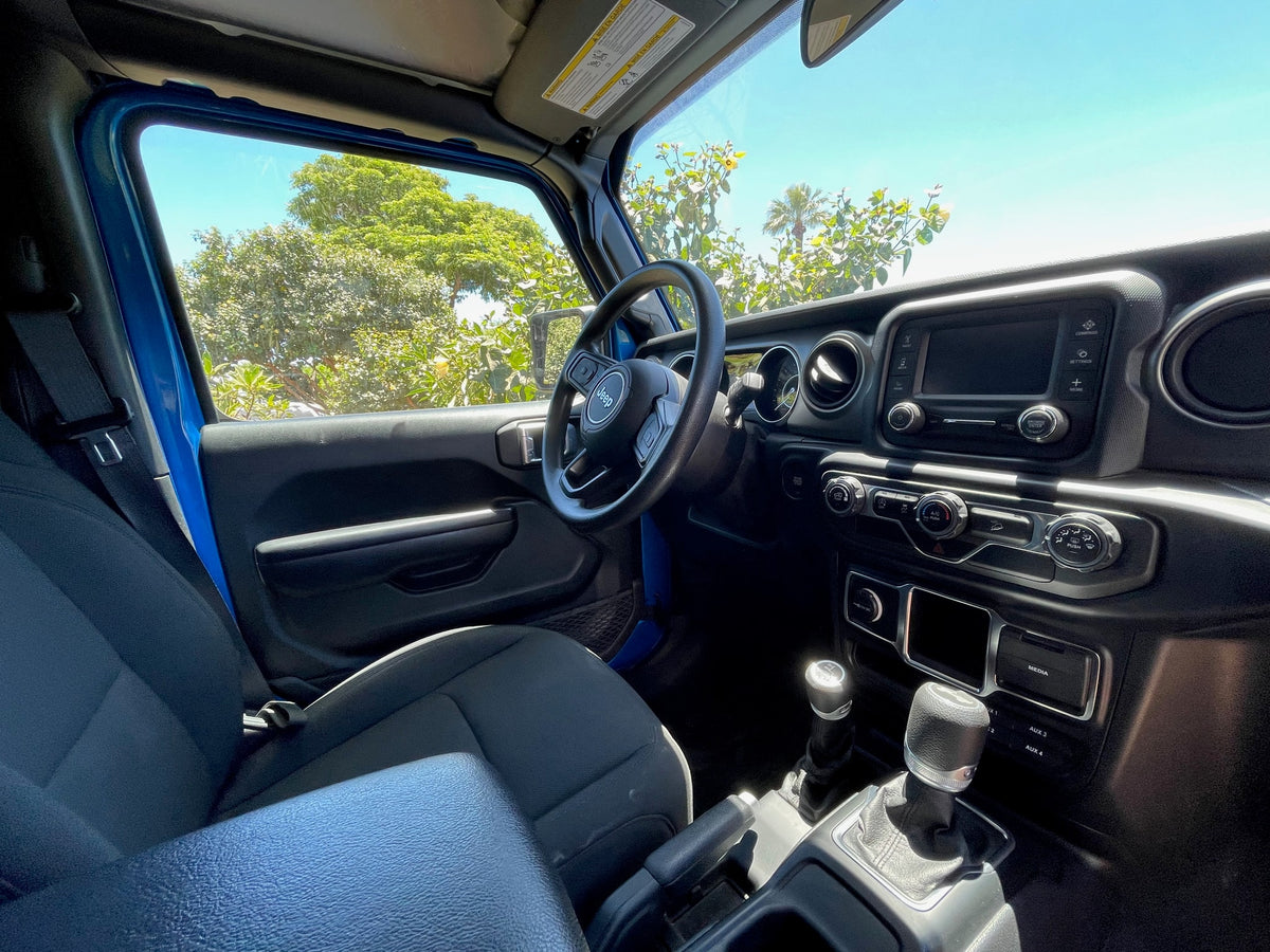 Bright blue Jeep interior, perfect for your next rv rental adventure. Shows dashboard, steering wheel, and manual shifter. — photo 20