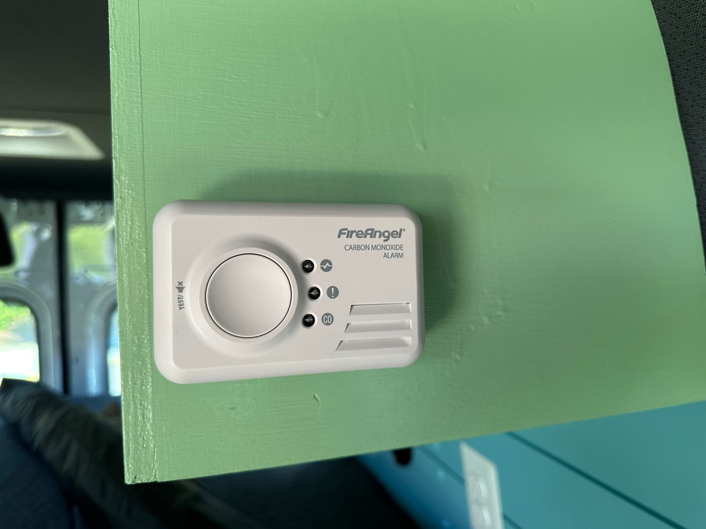 White FireAngel Carbon Monoxide alarm on a light green panel, a key safety feature for your rv rental experience. — photo 16