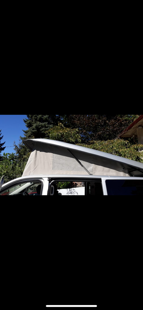 RV rental: White pop-top camper van, roof raised with tan fabric tent and mesh window, perfect for travel.