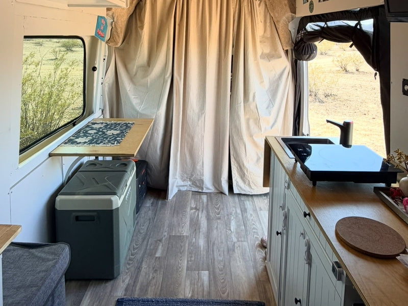  a cat rests below.|Cozy RV rental bedroom featuring a bed with blue & white patterned bedding — photo 5