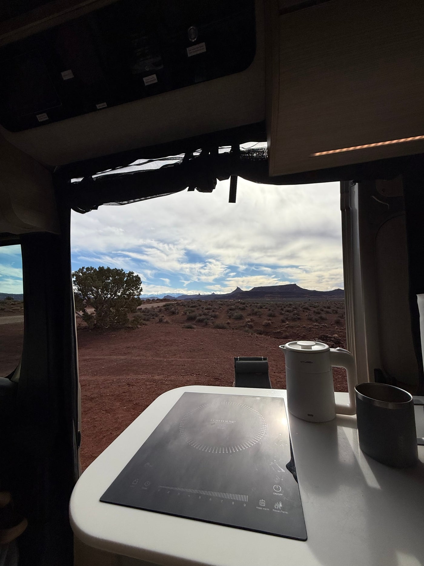 Enjoying desert views from an RV rental's kitchen. A CONTOURE induction cooktop, kettle, and mug are ready for camp meals. — photo 9