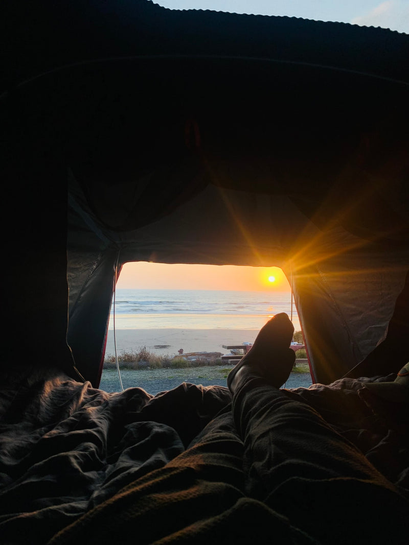Cozy RV rental sunrise view: feet propped up, watching the golden sun rise over a tranquil beach and ocean. — photo 6