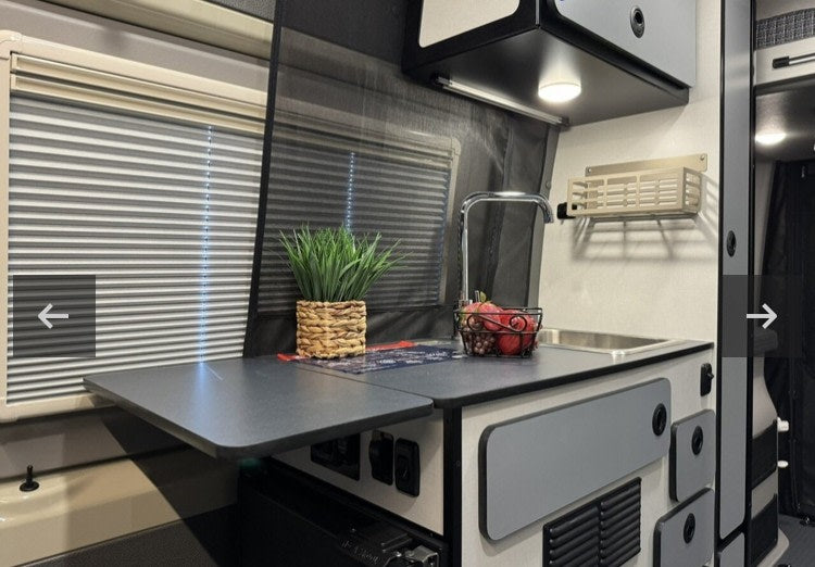  surrounded by tall pine trees.|RV rental floor plan for a camper van — photo 7