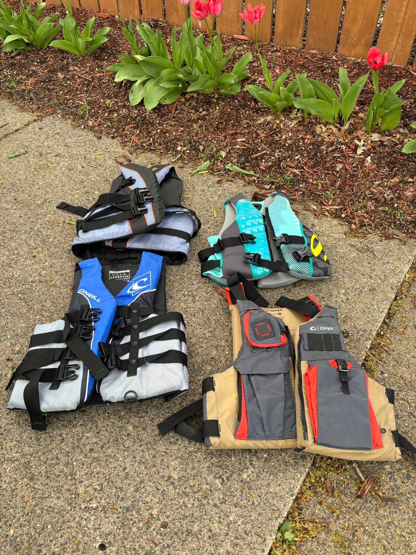 Water safety gear: O'Neill & Onyx life jackets/PFDs on concrete, ready for your RV rental adventures.