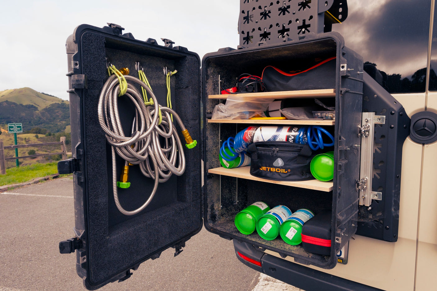 RV rental ready: see a customized external storage case organized with a shower hose, Jetboil, and camping fuel canisters.