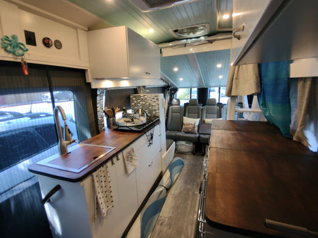 Spacious RV rental interior with modern kitchen, seating, and comfortable living space. Ideal for travel.