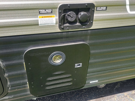  with a window view of green grass.|Compact RV rental bathroom: white toilet on a raised platform next to a shower stall.|Digital thermostat in an RV rental