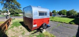 Cool vintage travel trailer, perfect for an RV rental adventure! This red & silver classic is parked under sunny skies.