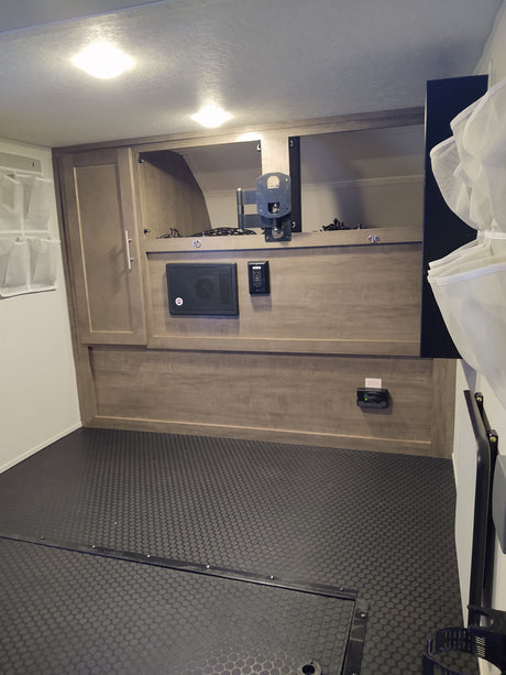 rv rental: RV interior with wood-look cabinets, multimedia control panel, TV mount, and textured utility flooring.