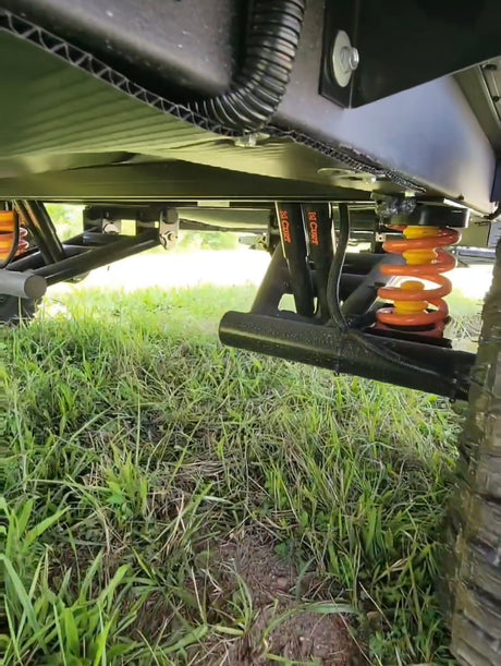 Undercarriage view of an RV rental, showing robust CURT suspension with orange coil springs, ready for off-road adventures.