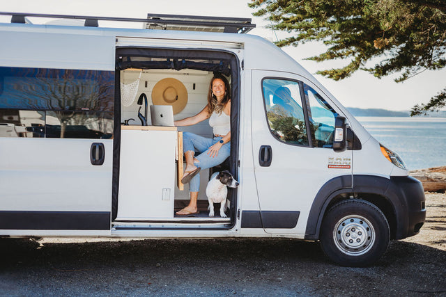 Woman & dog enjoying van life in a scenic RV rental.