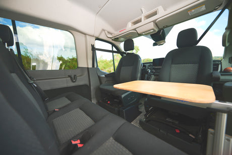 RV rental van interior with flexible seating, a central table, and large windows for scenic travels.