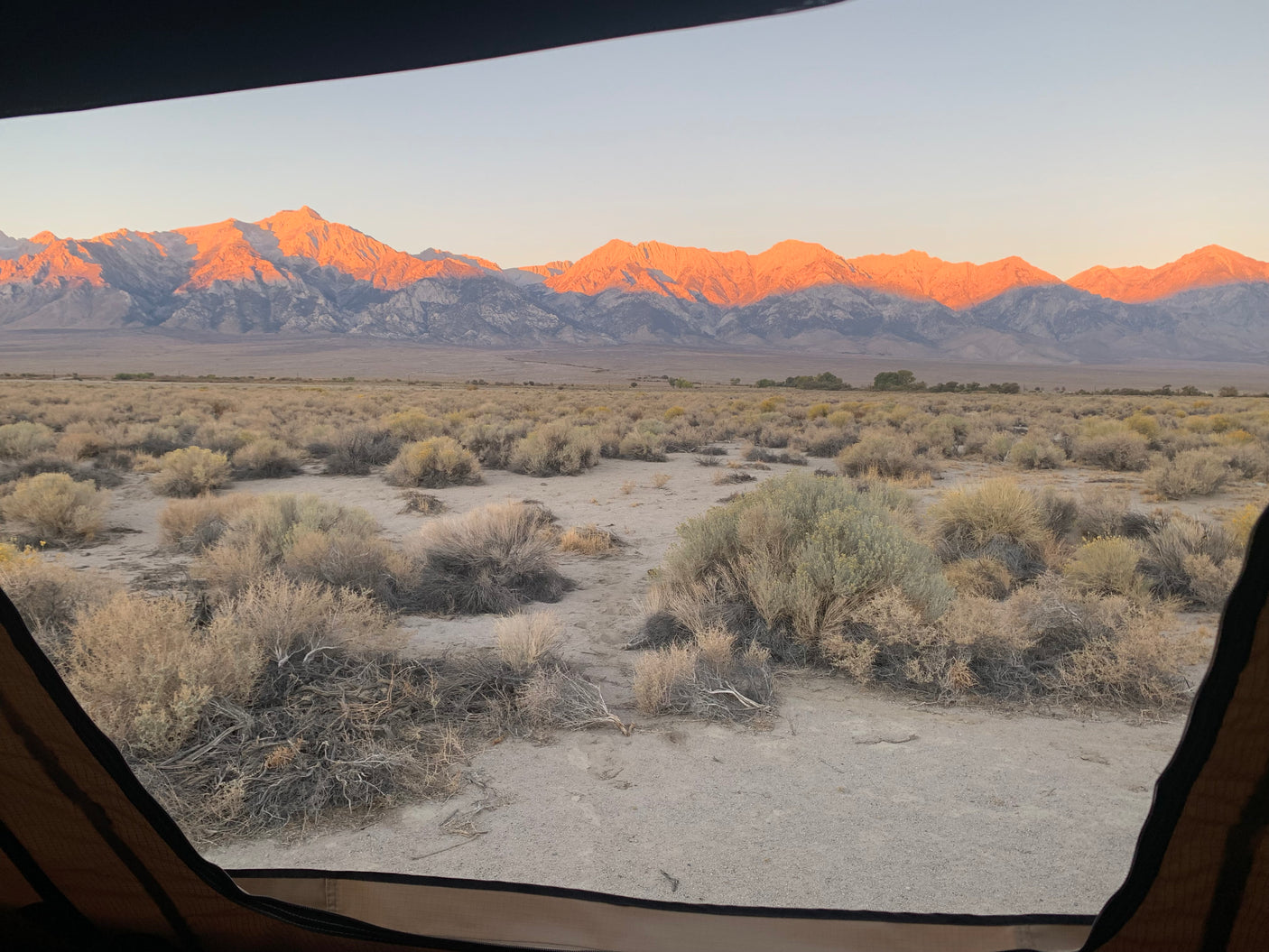 Waking up to golden hour mountains from an RV rental. Expansive desert view with beautiful natural light.