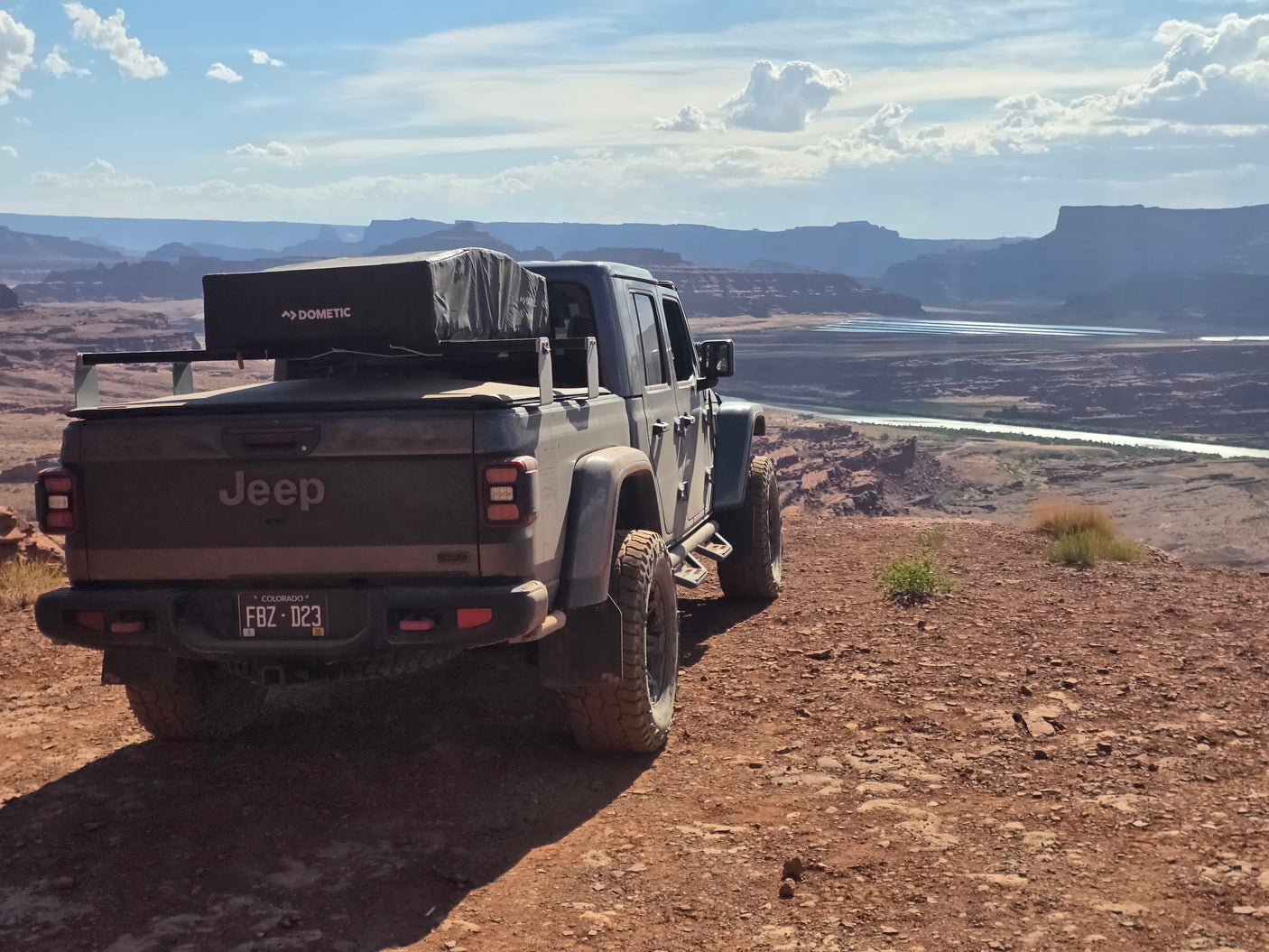 Jeep Gladiator RV rental with Dometic rooftop tent on a scenic desert overlook. Perfect for off-road camping.