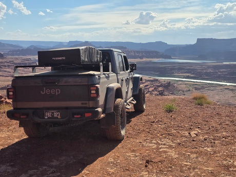Jeep Gladiator RV rental with Dometic rooftop tent on a scenic desert overlook. Perfect for off-road camping.
