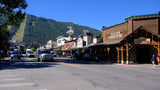 A bustling main street with shops like Five & Dime, backed by ski slopes, ideal for a mountain rv rental trip.