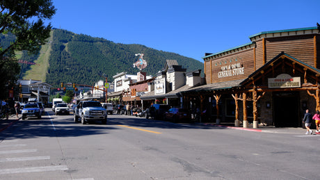 A bustling main street with shops like Five & Dime, backed by ski slopes, ideal for a mountain rv rental trip.