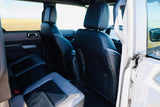 Comfortable rear seats of a rental vehicle, ready for your next RV rental adventure. View from the car interior shows fields.