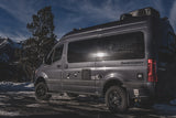 A gray Sprinter van RV rental, branded 'Sanctuary', is parked in a snowy mountain setting, ready for your next adventure.