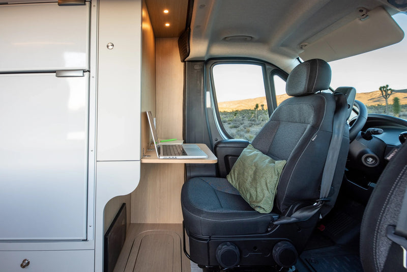 Modern RV rental interior: workspace with laptop, comfy seat, and stunning desert views through the window. — photo 6