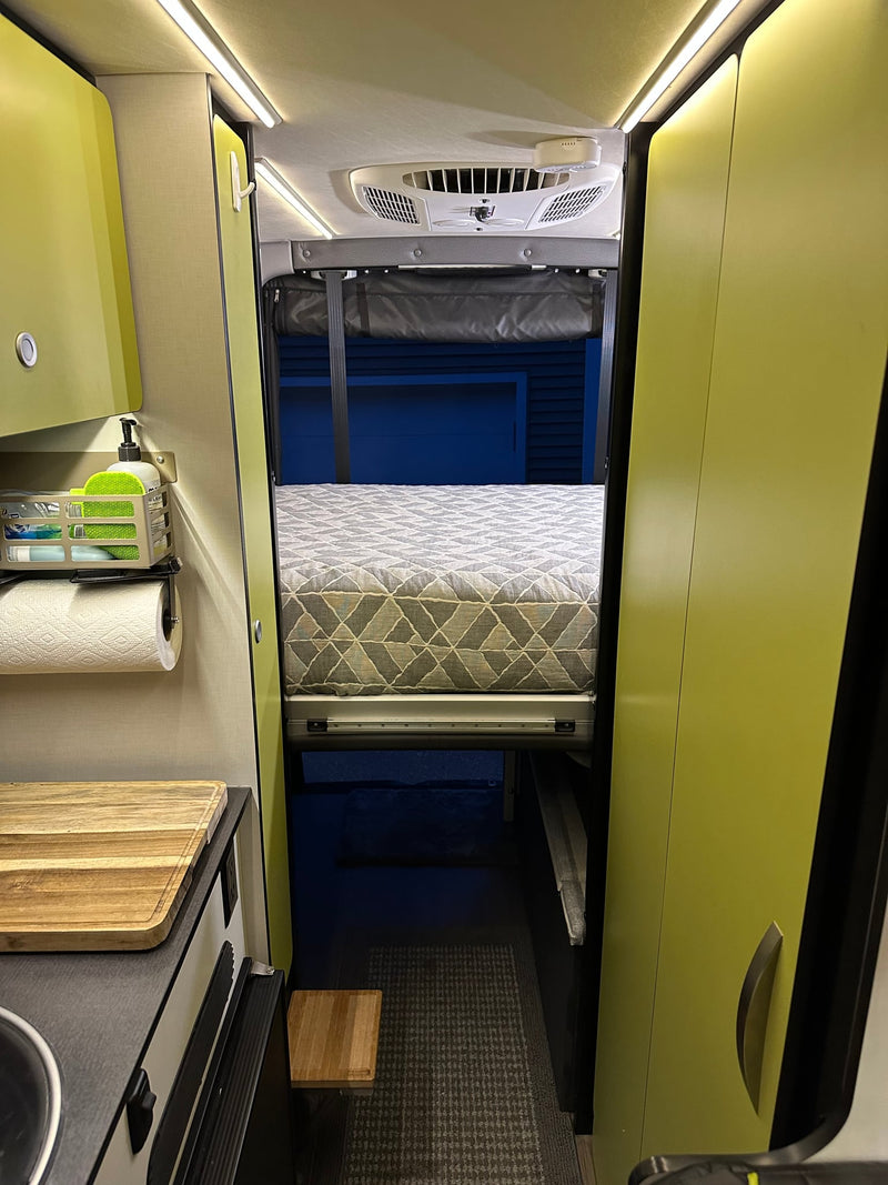  and integrated storage for versatile mobile living.|Inside a modern RV rental: striped seating — photo 18