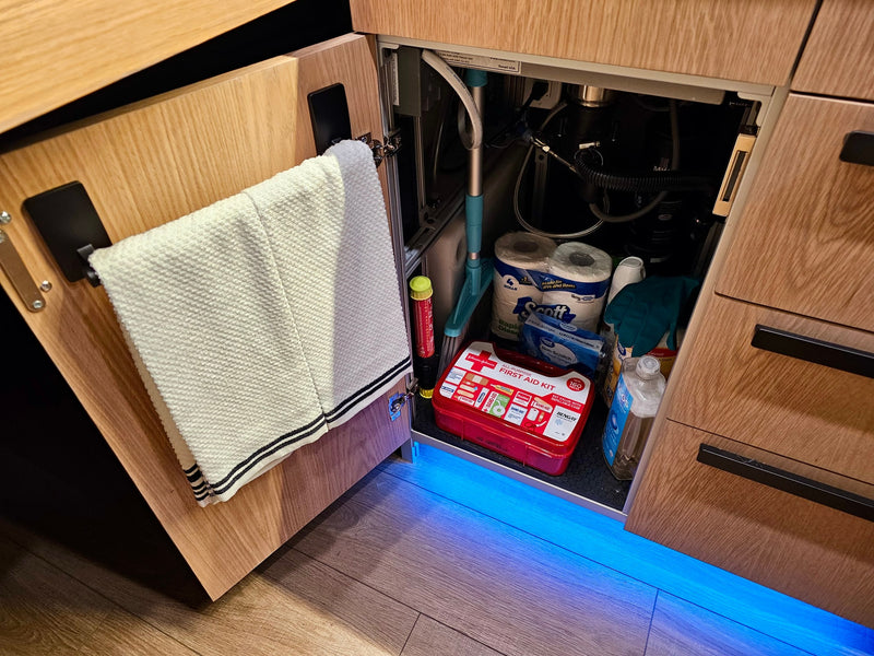 Under-sink essentials for an rv rental: first aid kit, fire extinguisher, cleaning gear & RV-specific toilet paper. — photo 15