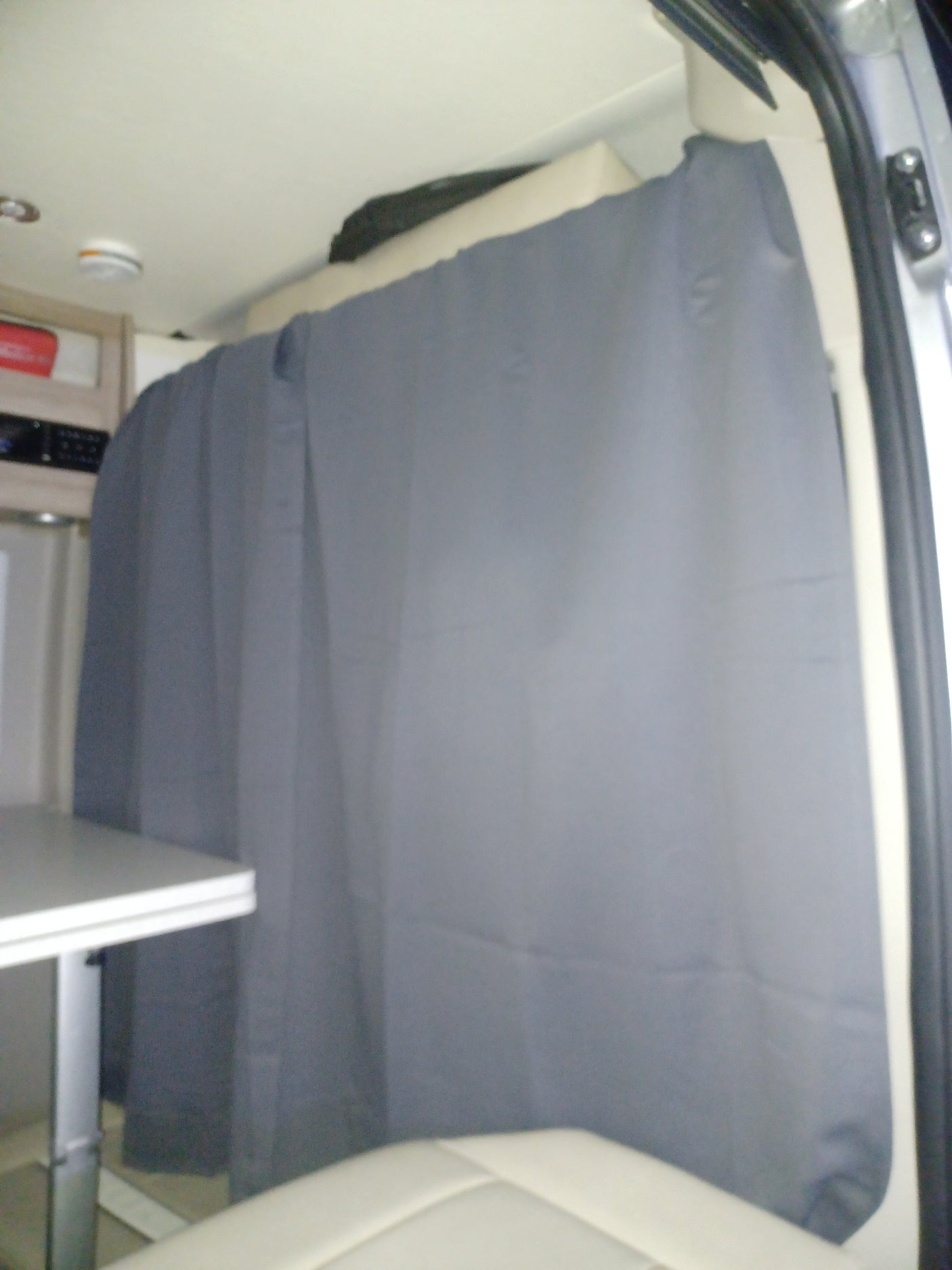 RV rental interior: A grey privacy curtain is drawn across the back of the mobile living space, offering shade and seclusion.
