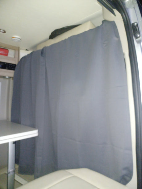 RV rental interior: A grey privacy curtain is drawn across the back of the mobile living space, offering shade and seclusion.
