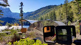 Experience nature: This RV rental, a shiny teardrop trailer, opens to a cozy interior and kitchenette, set by a scenic lake and mountains.