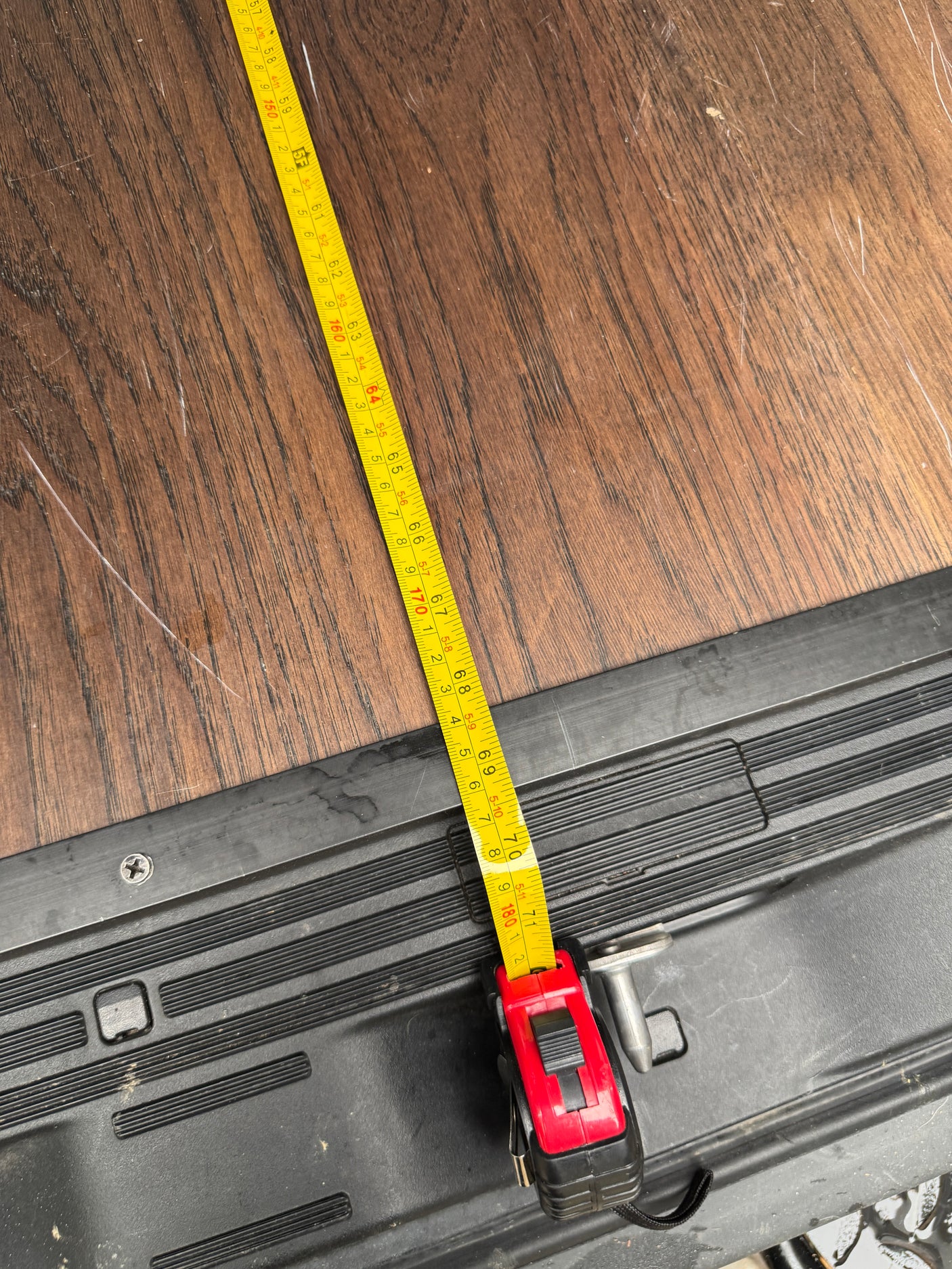 Measuring the spacious interior floor of an RV rental. Tape shows 71 inches (180 cm) on wood-look flooring.