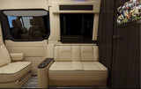 Luxury RV rental interior showcasing beige quilted leather seating, a mounted TV, and window blinds for premium travel.