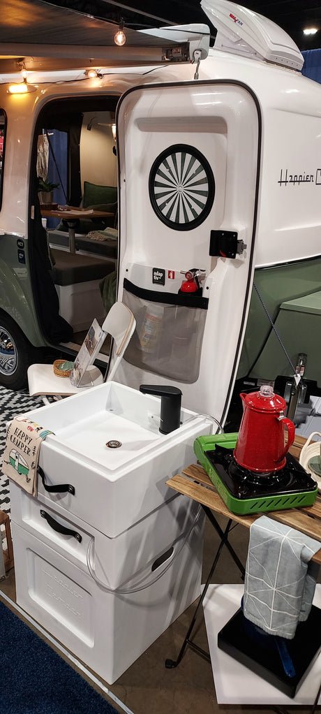 Compact Happier Camper RV rental with a versatile outdoor kitchen: sink, stove, and adaptable interior for camping adventures.