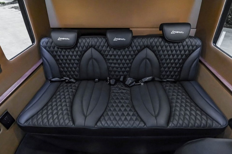 Experience luxury rv rental travel! This interior features three plush, diamond-quilted black leather seats with 'Legend' headrests. — photo 15