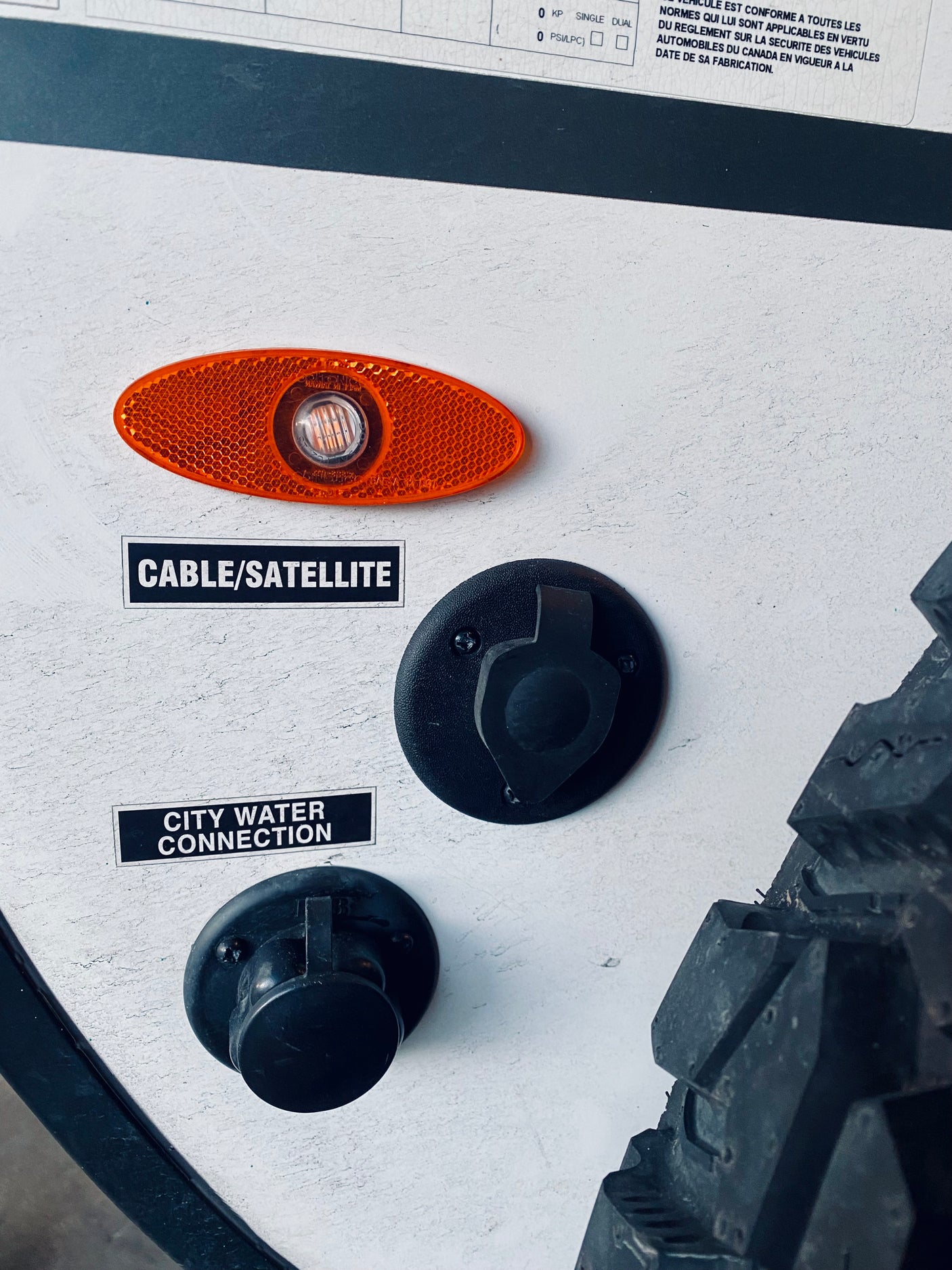 RV rental side: cable/satellite & city water connections, plus an orange marker light. Essential utilities.