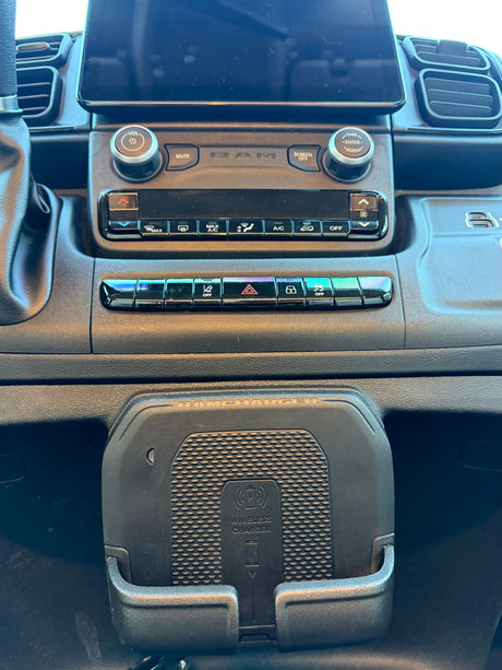 RV rental dash showing a modern infotainment system, climate controls, and a "RAMCHARGER" wireless phone charger.