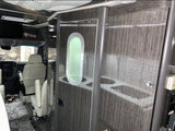 Interior of an RV rental, showcasing the driver's cabin with swivel chairs, and a modern wooden door with an oval porthole.